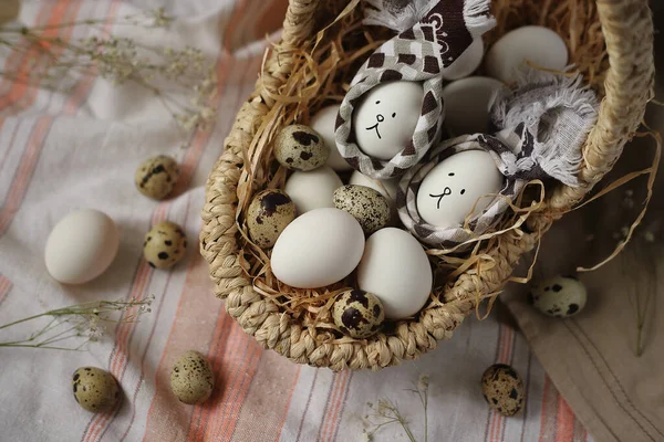 İki Paskalya yumurtası bir sepetin içinde tavşancık şeklinde ve peçetenin üzerinde çiçeklerle süslenmiş yumurtalar. Paskalya konsepti.