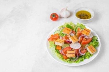 Geleneksel Ortadoğu vejetaryen salatası. Lübnan mutfağı tarifi. Taze sebze, kiraz, marul, kızarmış pita ekmeği. Beyaz beton arka plan. Sağlıklı yemek. Boşluğu kopyala