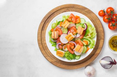 Geleneksel Ortadoğu vejetaryen salatası. Lübnan mutfağı tarifi. Taze sebze, kiraz, marul, kızarmış pita ekmeği. Beyaz beton arka plan. Sağlıklı yemek, güzel manzara. Boşluğu kopyala