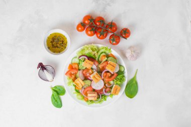 Geleneksel Ortadoğu vejetaryen salatası. Lübnan mutfağı tarifi. Taze sebze, kiraz, marul, kızarmış pita ekmeği. Beyaz beton arka plan. Düşük kalorili, sağlıklı yemek, üst manzara.. 