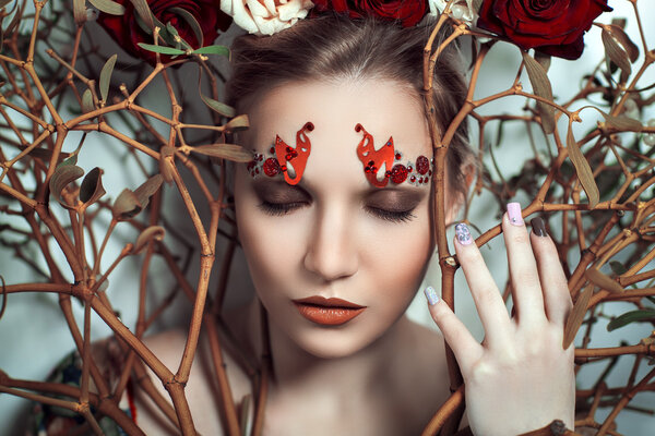 Beautiful young girl, lady, actress, model, character, tree, rose, fairy tale. Bold creative look, fashion style. Ideal expressive makeup, bright red lips, decor, accessory, headdress, branch, flowers