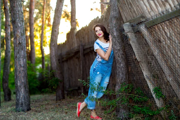 Bella ragazza vicino a una vecchia recinzione di legno — Foto Stock