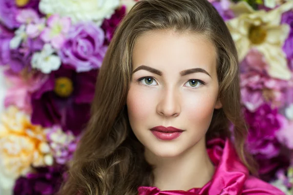 Bella ragazza vicino alla parete del fiore — Foto Stock