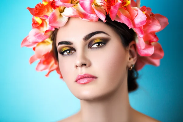 Retrato de uma menina bonita em uma grinalda de flores — Fotografia de Stock