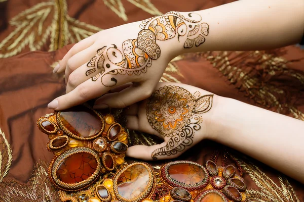 Dos mujeres manos mehendi imagen naranja brillante tela con pliegues — Foto de Stock