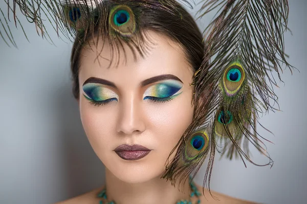 Oriental belleza con plumas de pavo real — Foto de Stock