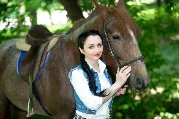 Beautiful girl near brown horse — Stock Photo, Image