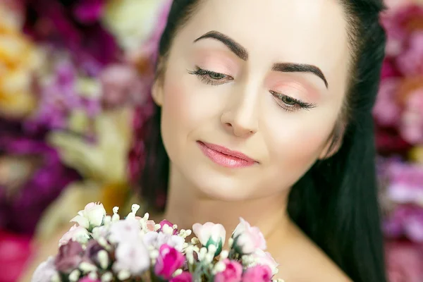 Schöne hübsche Frau mit Blumen — Stockfoto