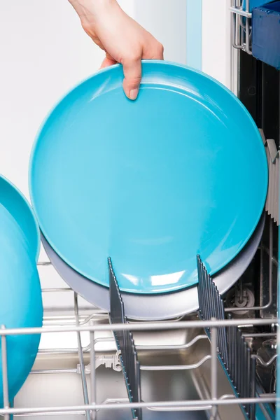 Mulher esvaziar a máquina de lavar louça — Fotografia de Stock