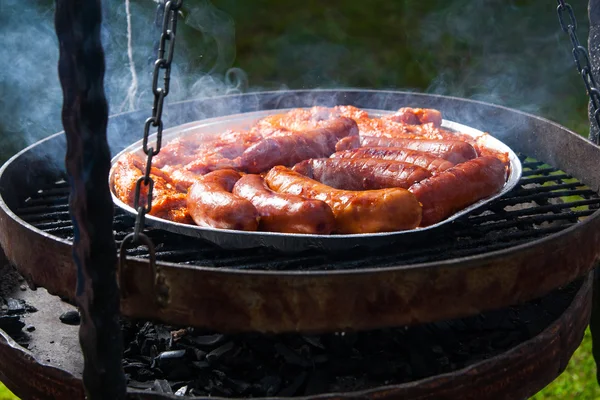 Sausages and bacon on grill tray — Stock Photo, Image