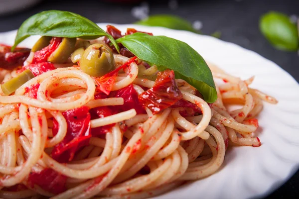 Spaghetti with tomatoes, garlic, basil, olives and olive oil — Stock Photo, Image