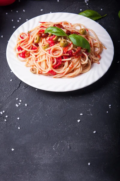 Spaghetti with tomatoes, garlic, basil, olives and olive oil — Stock Photo, Image