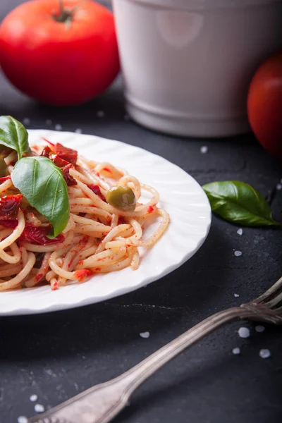 Spaghetti with tomatoes, garlic, basil, olives and olive oil — Stock Photo, Image