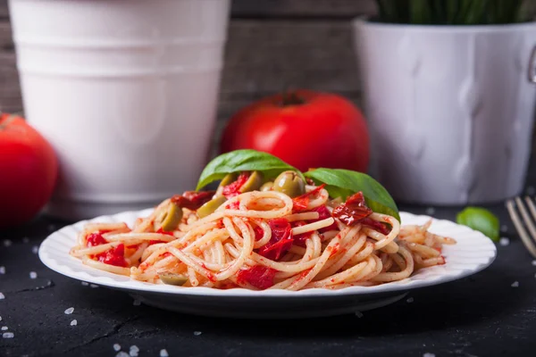 Spaghetti with tomatoes, garlic, basil, olives and olive oil — Stock Photo, Image