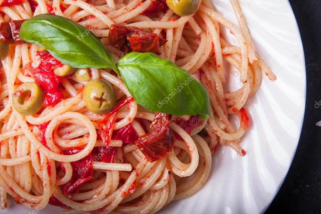 Spaghetti with tomatoes, garlic, basil, olives and olive oil — Stock Photo © fajerd 115496524
