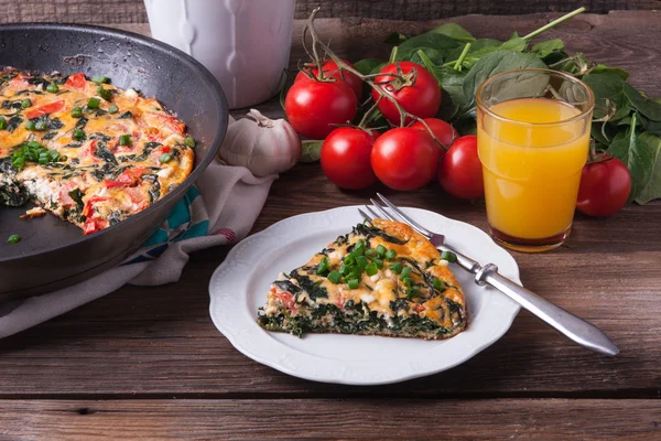 Frittata with spinach, tomatoes and cheese Stock Photo