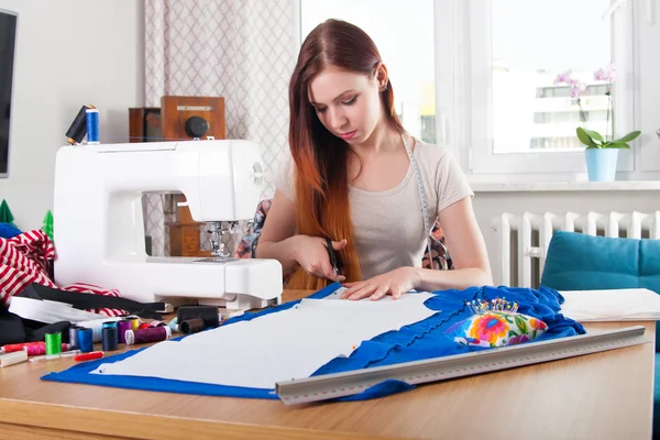 Woman cutting pattern from fabric Stock Image