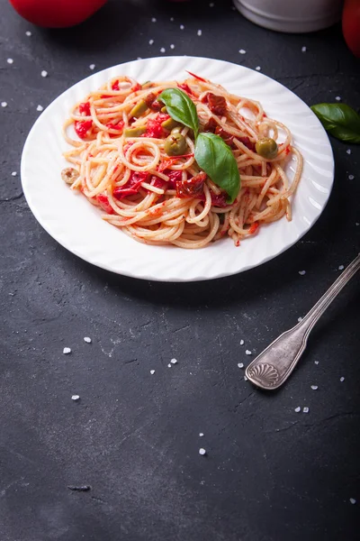 Espaguetis con tomates, ajo, albahaca, aceitunas y aceite de oliva Imagen de stock