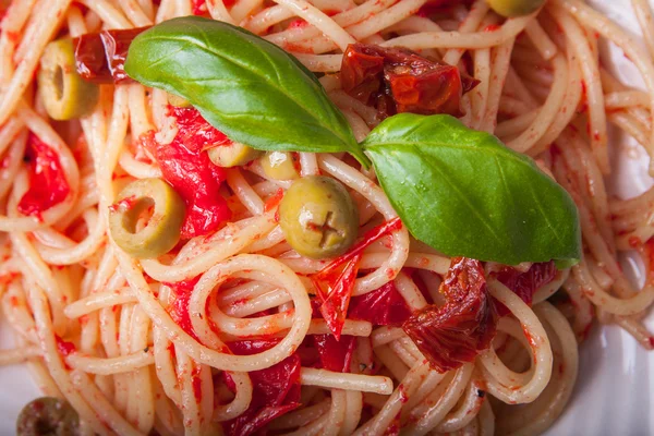 Espaguetis con tomates, ajo, albahaca, aceitunas y aceite de oliva Imagen de archivo