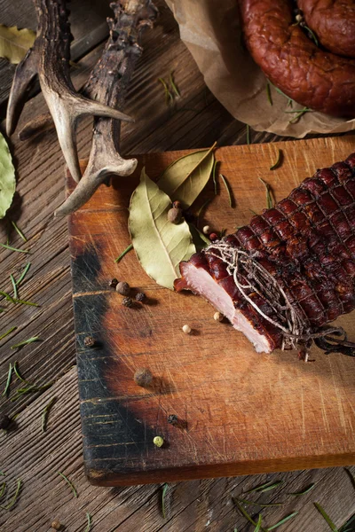 Jamón ahumado en una tabla de cortar . — Foto de Stock