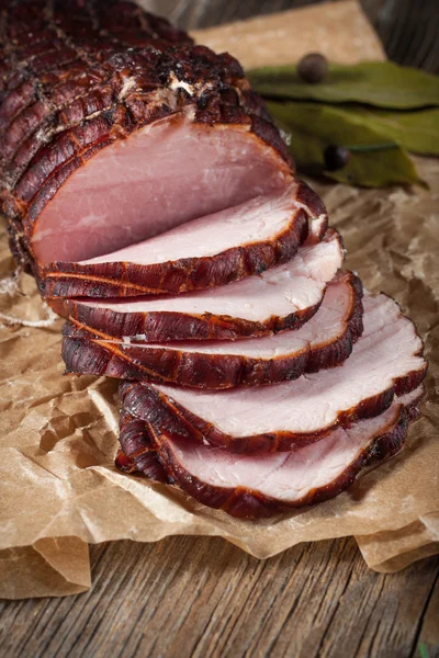 Gerookte ham op een snijplank. — Stockfoto