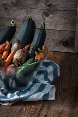 Bir cam şeffaf kase taze sebze.