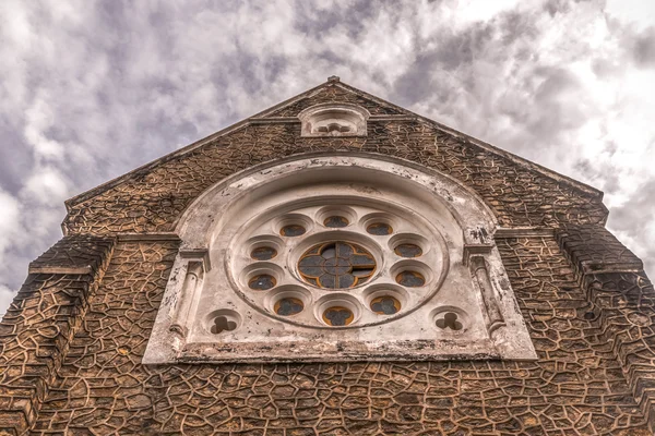 Facade of the Catholic church with a cloudy sky background — Stock Photo, Image