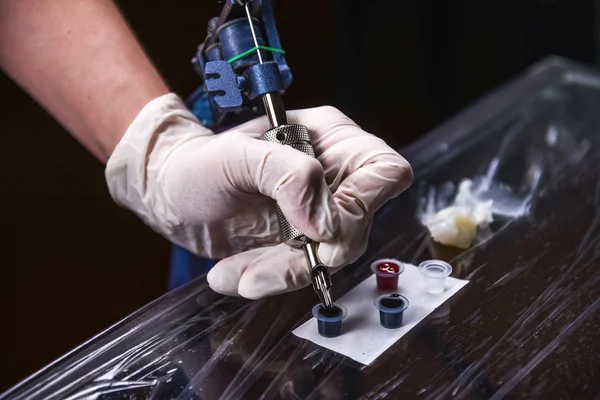 Tatooist segurando uma máquina de tatuagem — Fotografia de Stock