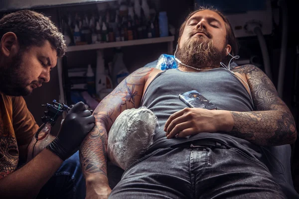 Tattooer gör tattoo i tatuerare — Stockfoto