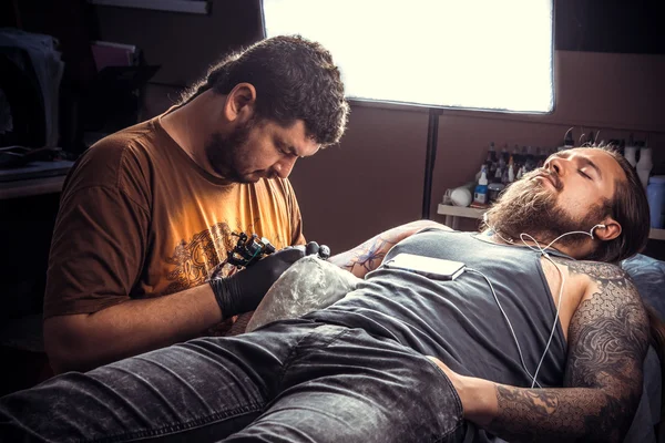Професійний татуювання позує в татуювальному салоні — стокове фото