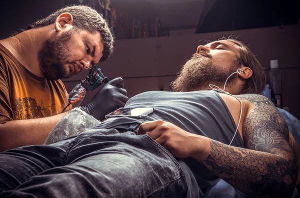 Dövme dövme salonunda çalışan profesyonel tattooer