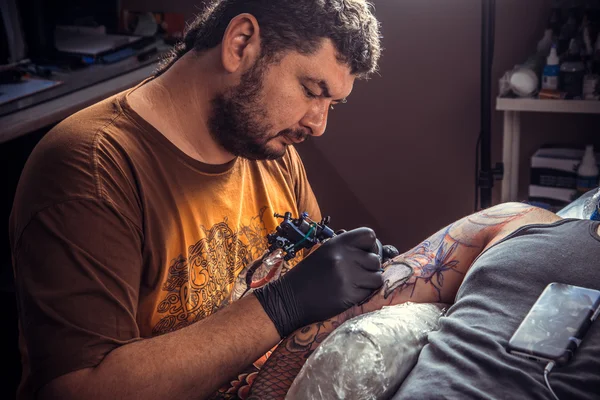 Tatuagem fazendo tatuagem no salão de tatuagem — Fotografia de Stock