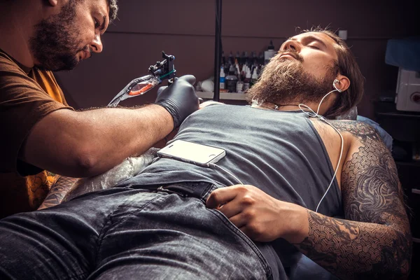 Especialista en tatuajes haciendo tatuaje en salón de tatuajes —  Fotos de Stock