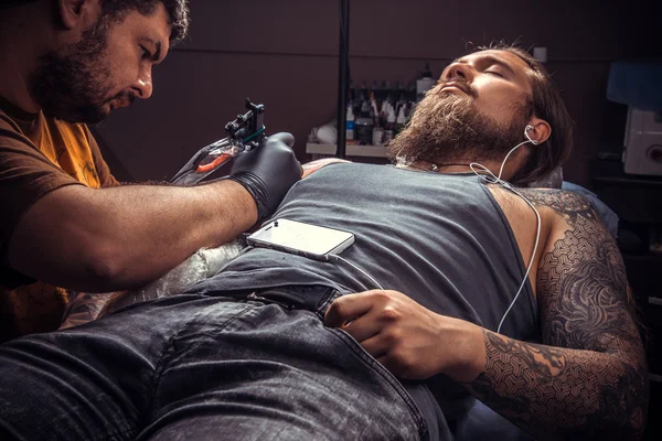 Tattooer pózol tetováló szalon — Stock Fotó