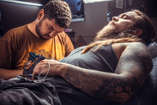 Professionella tattooer visar processen för att göra en tatuering i tatuerare — Stockfoto