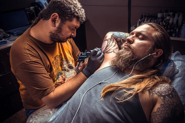 Especialista em tatuagem faz imagens de tatuagem em sala de tatuagem — Fotografia de Stock