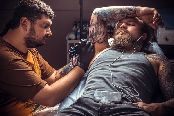 Tattoo master at work in tattoo parlor — Stock Photo, Image