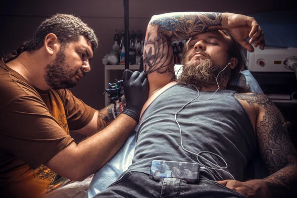 Tatuagem faz tatuagem legal na sala de tatuagem — Fotografia de Stock