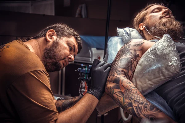 Professionele tatoeage kunstenaar aan het werk in tattoo salon — Stockfoto