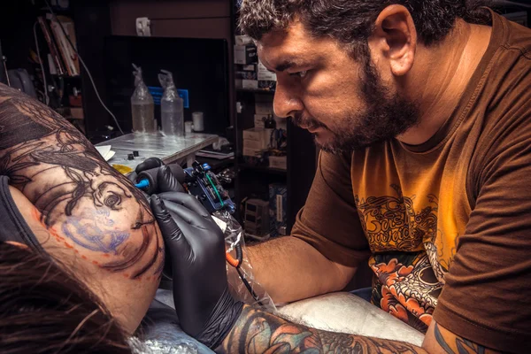 Tattoo specialist create tattoo in tattoo parlor — Stock Photo, Image