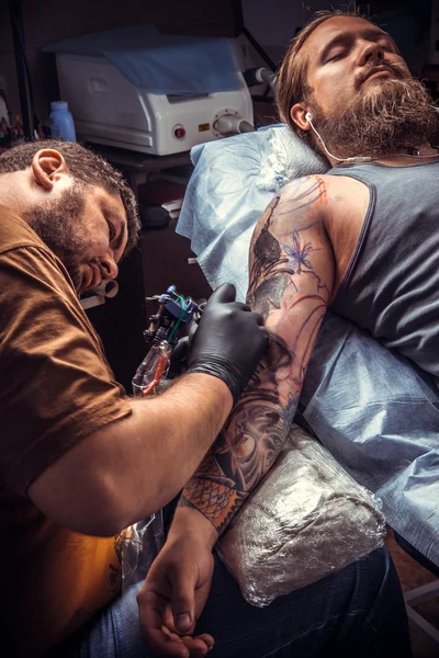 Artista de tatuagem profissional fazendo tatuagem no salão de tatuagem — Fotografia de Stock