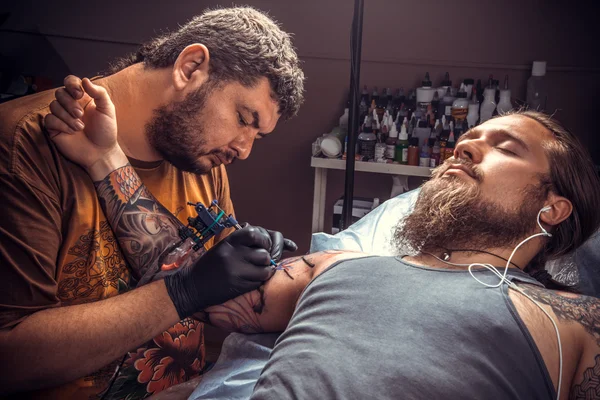 Master makes cool tattoo in tattoo studio — Stock Photo, Image