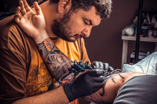 Профессиональный татуировщик, работающий в студии — стоковое фото
