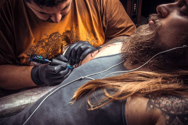 Master gör cool tatuering i tatueringsstudio — Stockfoto