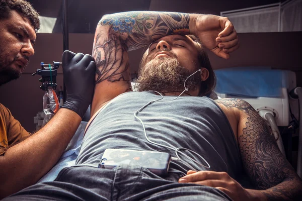 Artista de tatuagem fazendo uma tatuagem no salão de tatuagem — Fotografia de Stock