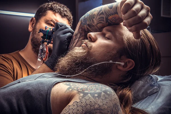 Master gör cool tatuering i tatueringsstudio — Stockfoto