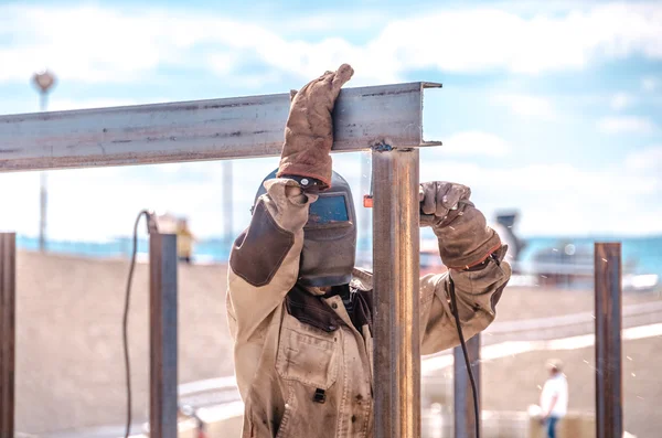 Trabajador soldador en una máscara protectora con máquina de soldadura de gas al aire libre —  Fotos de Stock