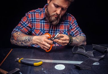 Profesyonel Deri İşçisi atölyesindeki yeni yapımı için deri kaplama kesiyor.