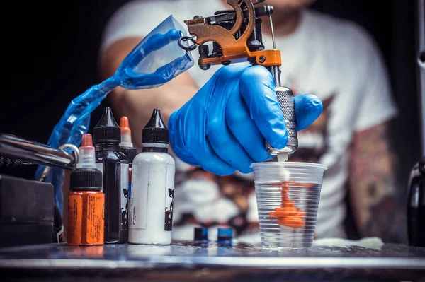 Mano di un tatuatore con una pistola tatuaggio. — Foto Stock