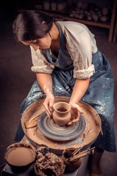 Wanita tuan muda yang cantik mendemonstrasikan proses pembuatan hidangan keramik menggunakan teknologi lama. Handwork. — Stok Foto
